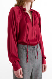 Blusa satinata con laccetti e volant